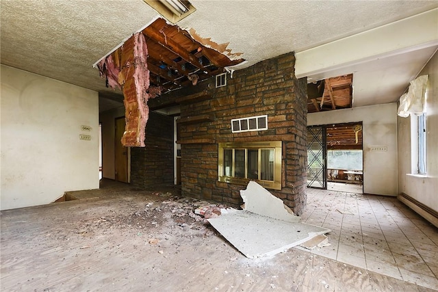 unfurnished living room featuring a fireplace and a baseboard heating unit