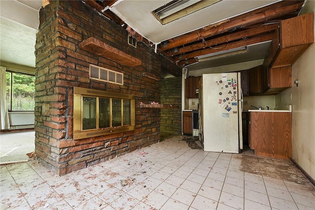 interior space with white fridge, electric stove, a fireplace, and brick wall