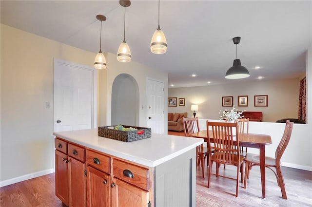 kitchen featuring a kitchen island, light wood-type flooring, and hanging light fixtures