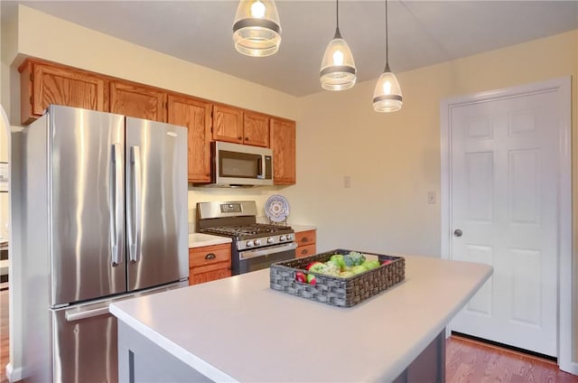 kitchen featuring stainless steel appliances, a kitchen island, hanging light fixtures, and dark hardwood / wood-style floors