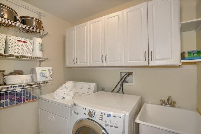 washroom featuring cabinets, washing machine and dryer, and sink