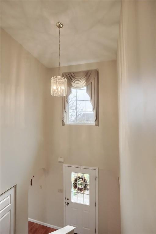 foyer entrance featuring hardwood / wood-style flooring and a notable chandelier