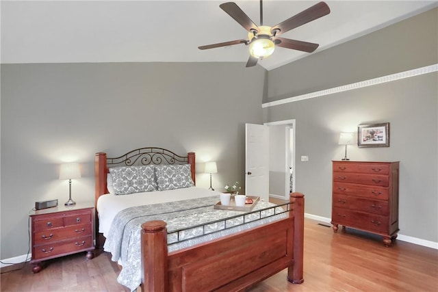 bedroom with ceiling fan, hardwood / wood-style floors, and high vaulted ceiling