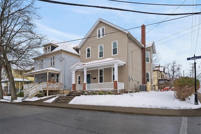 view of property featuring central AC unit and a porch