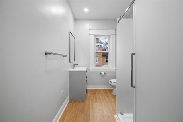 bathroom with hardwood / wood-style flooring, vanity, and toilet