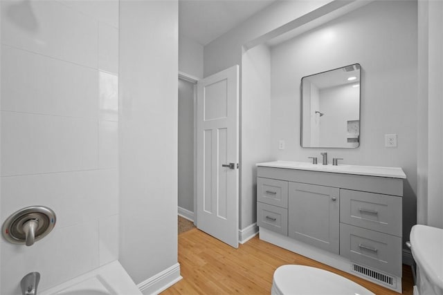 bathroom with hardwood / wood-style floors, vanity, and toilet