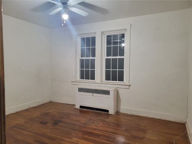 unfurnished room with dark hardwood / wood-style flooring, radiator, and ceiling fan