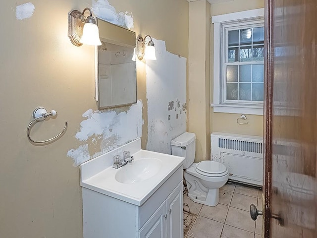 bathroom featuring tile patterned flooring, radiator heating unit, vanity, and toilet