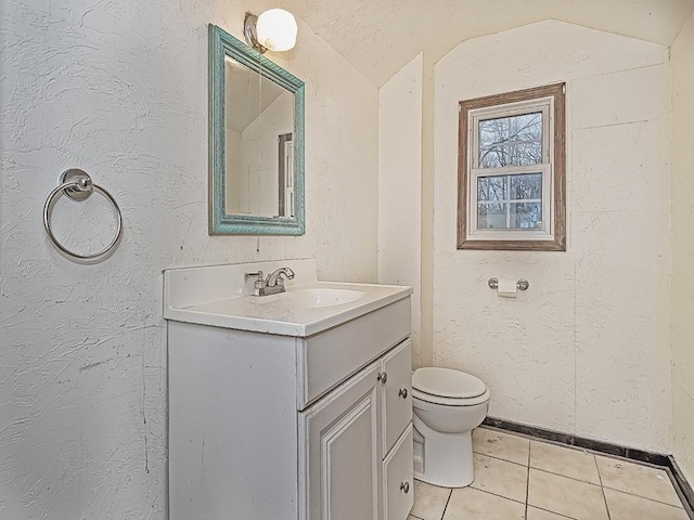 bathroom with a textured ceiling, tile patterned flooring, vanity, and lofted ceiling