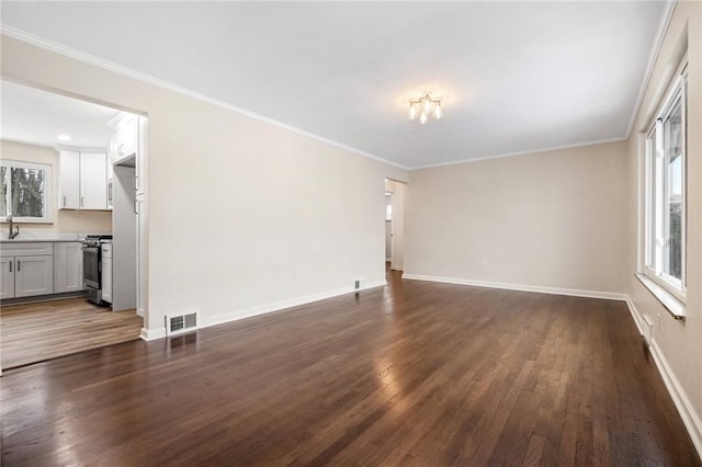 unfurnished living room with a healthy amount of sunlight, dark hardwood / wood-style flooring, and crown molding