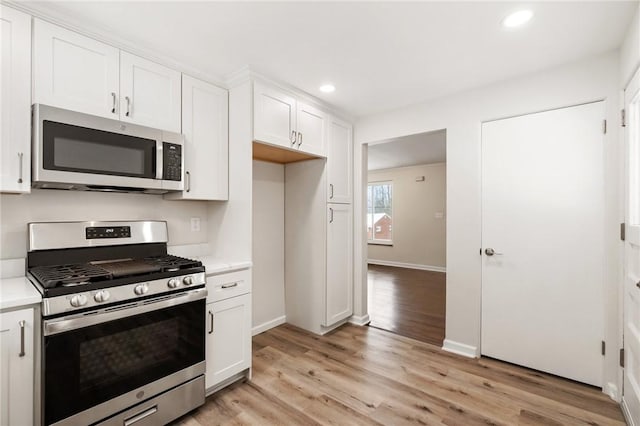 kitchen with white cabinets, stainless steel appliances, and light wood-type flooring