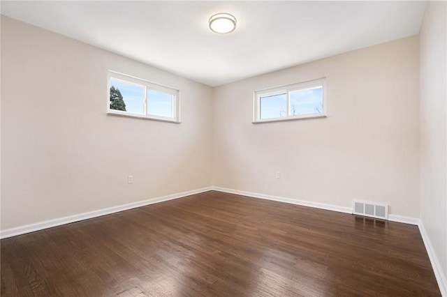 unfurnished room with dark wood-type flooring