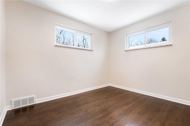 unfurnished room with dark wood-type flooring