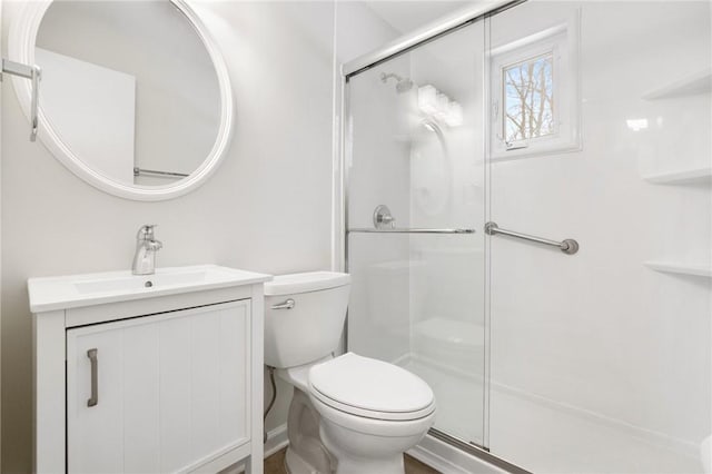 bathroom featuring an enclosed shower, vanity, and toilet