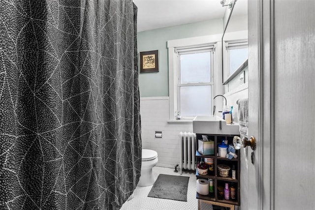 bathroom featuring radiator heating unit, a shower with curtain, tile patterned floors, toilet, and tile walls