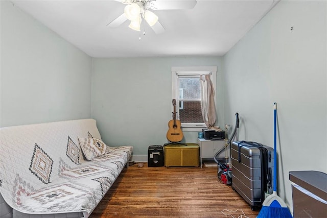 living area with ceiling fan and dark wood-type flooring