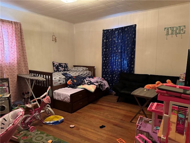 bedroom with hardwood / wood-style floors and ornamental molding