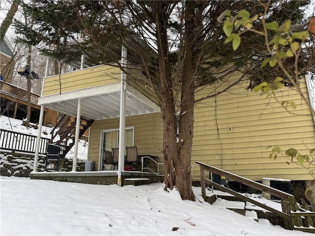 snow covered property with central AC unit