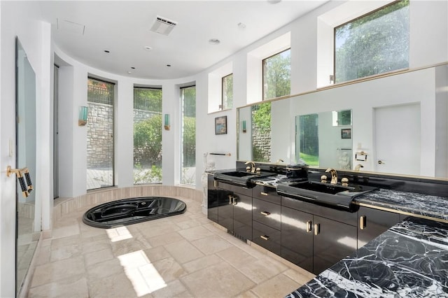 bathroom featuring a bathing tub, a towering ceiling, and vanity