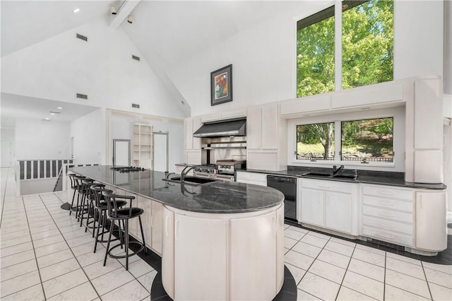 kitchen featuring ventilation hood, a kitchen island with sink, high vaulted ceiling, black dishwasher, and white cabinetry