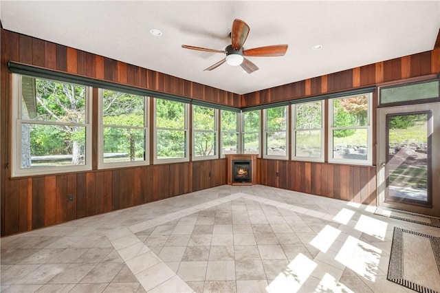 unfurnished sunroom with ceiling fan and a healthy amount of sunlight