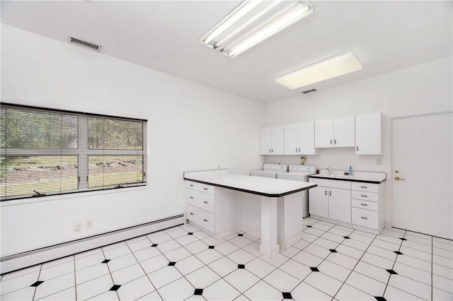 kitchen featuring white cabinets, a baseboard radiator, washer and dryer, and sink