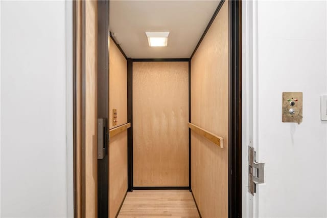 room details featuring elevator and wood-type flooring