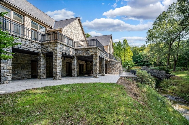 back of house with a lawn, a balcony, and a patio