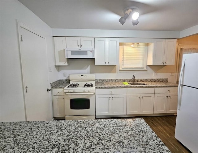 kitchen featuring light stone counters, white appliances, dark wood-type flooring, sink, and white cabinetry