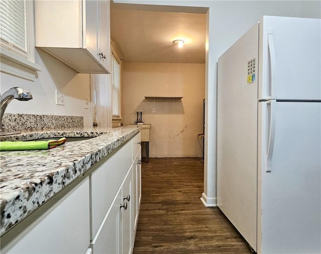 kitchen featuring light stone counters, sink, white cabinets, and white refrigerator