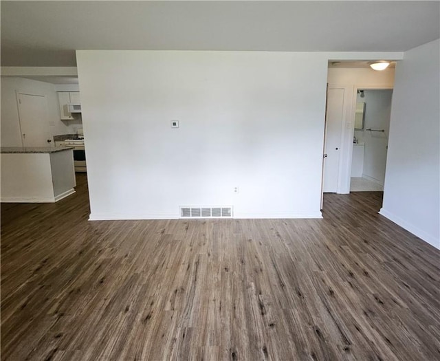 unfurnished room with dark wood-type flooring