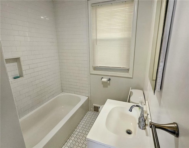 full bathroom with sink, tile patterned flooring, tiled shower / bath combo, and toilet