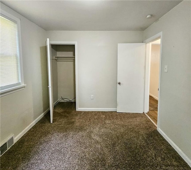 unfurnished bedroom with carpet, multiple windows, and a closet