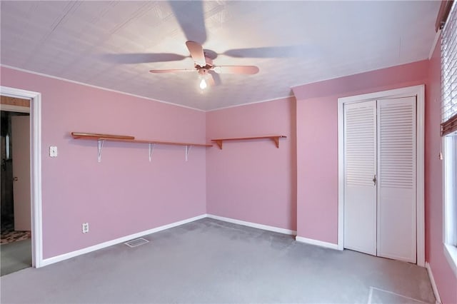 unfurnished bedroom with a closet, ceiling fan, and dark colored carpet