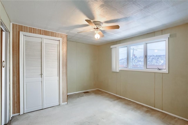 unfurnished bedroom with ceiling fan, light colored carpet, and a closet