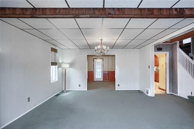 unfurnished room featuring a paneled ceiling and a chandelier