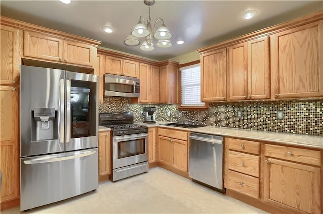 kitchen featuring tasteful backsplash, appliances with stainless steel finishes, sink, and pendant lighting