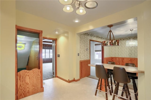 dining area featuring light carpet and a notable chandelier