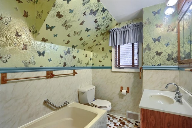 bathroom featuring vanity, a bathing tub, and toilet