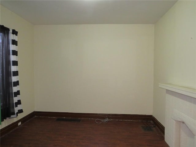 unfurnished room with dark hardwood / wood-style flooring