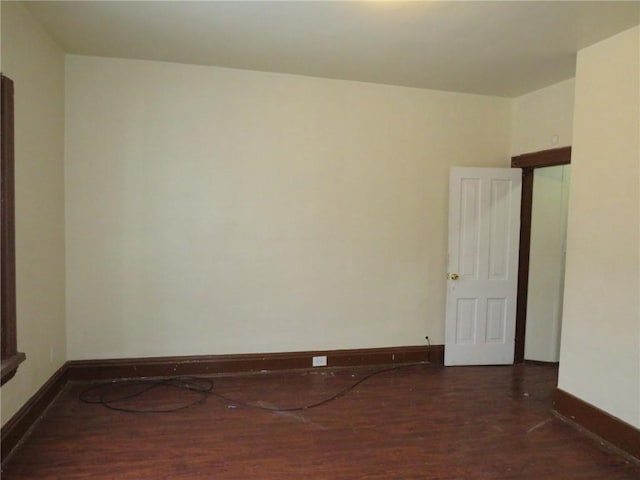 empty room with dark hardwood / wood-style flooring