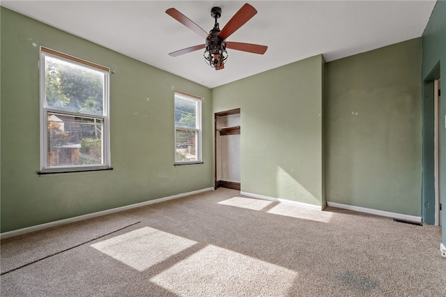 carpeted spare room with ceiling fan