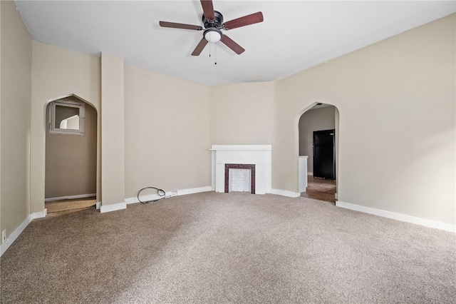 unfurnished living room featuring ceiling fan and carpet floors