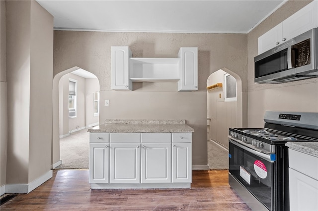 kitchen with white cabinetry, carpet floors, and stainless steel appliances