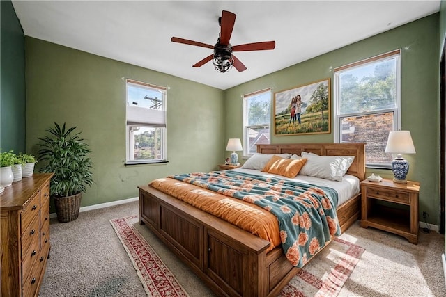 bedroom with multiple windows, light carpet, and ceiling fan