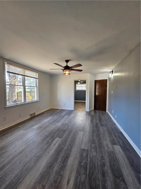 unfurnished living room with ceiling fan and dark wood-type flooring