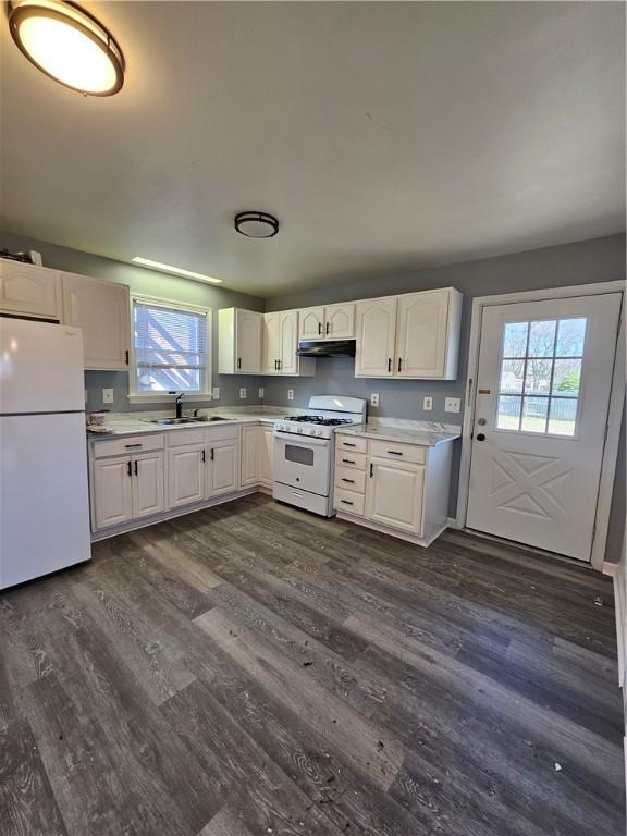 kitchen with white cabinets, dark hardwood / wood-style flooring, white appliances, and sink