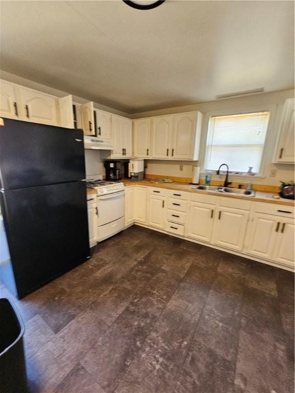 kitchen featuring black refrigerator, white cabinetry, white gas stove, and sink