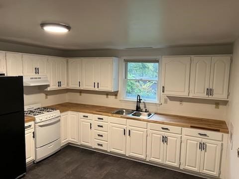 kitchen with white cabinets, black fridge, sink, gas range gas stove, and extractor fan