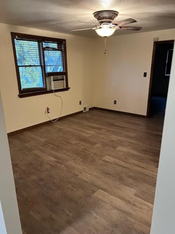 spare room featuring ceiling fan, cooling unit, and dark hardwood / wood-style floors